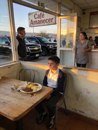 Yo solo pensaba que le estaba dando desayuno a un niño pobre. Hasta el día en que cuatro Suburban blindadas se detuvieron frente a mi café…